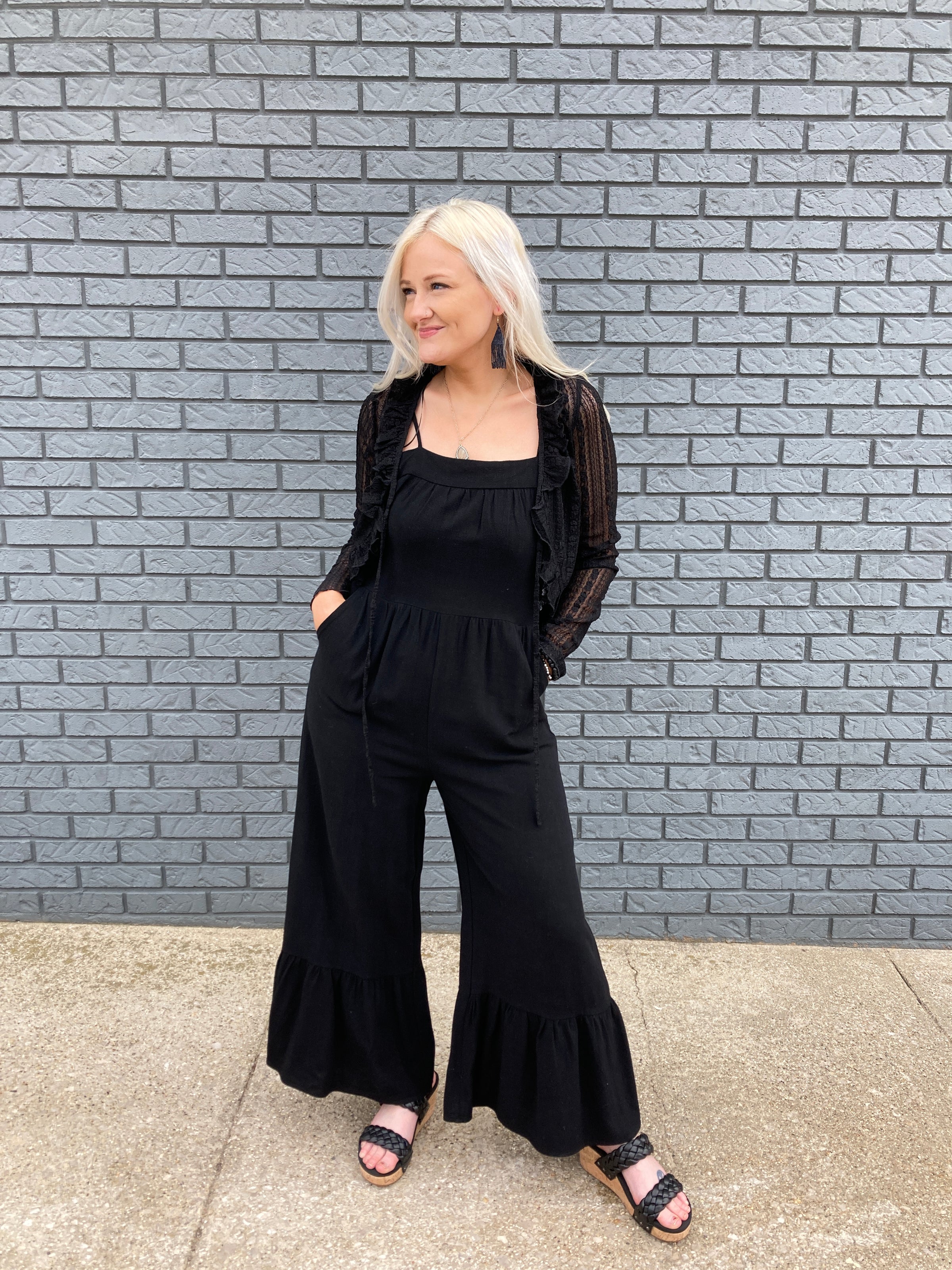 A gorgeous 30 something woman in a stunning wide leg black jumpsuit.