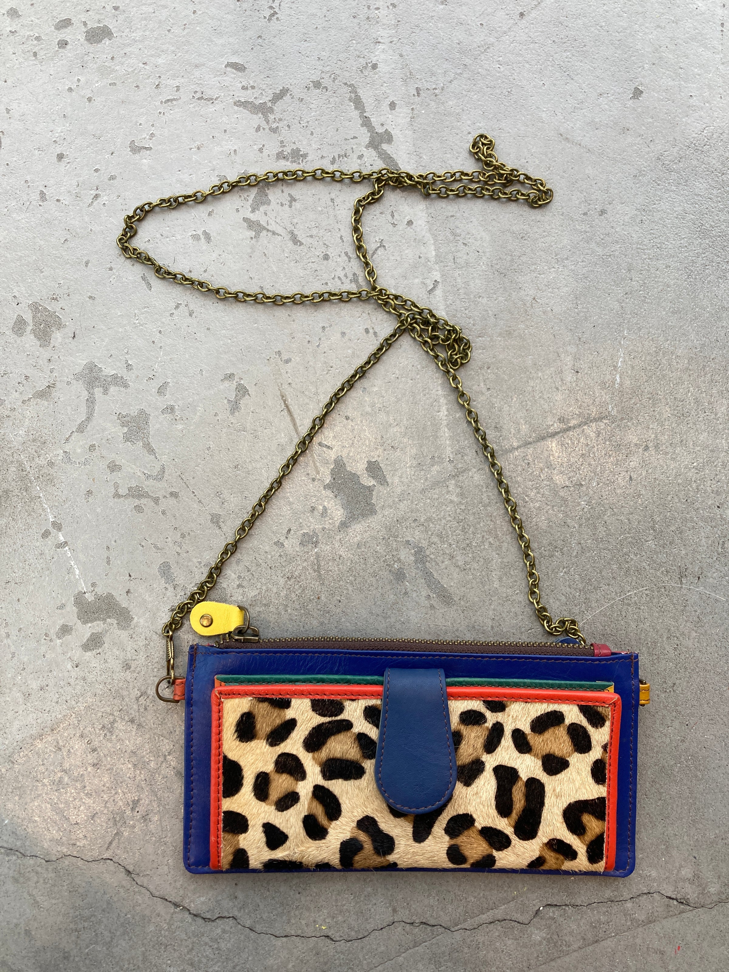 A small colorful leopard print clutch with a brass chain