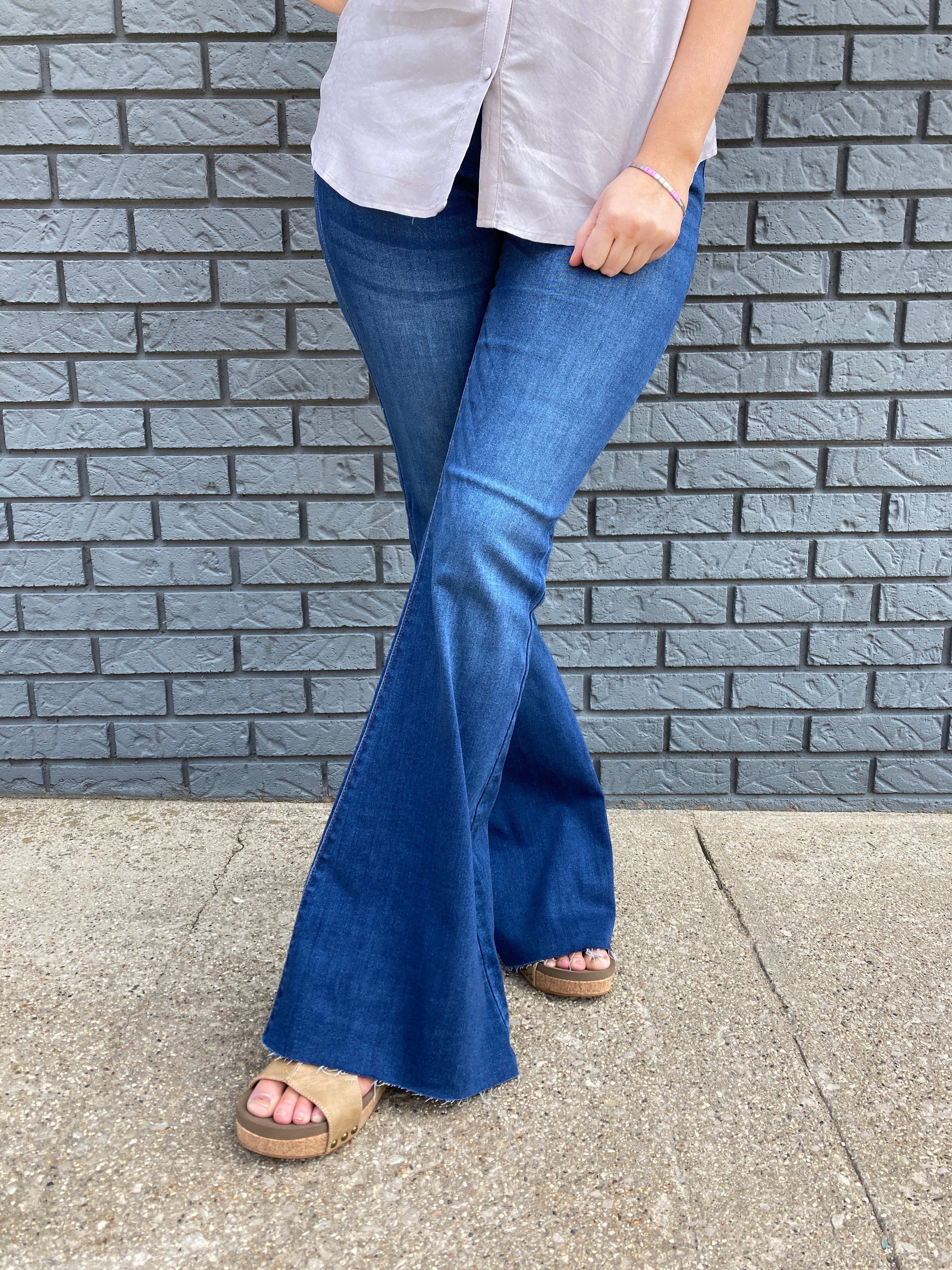 You will slide right into these super wide bell bottom jeans. They are ultra comfy and are paired with a pair of brown platform sandals.