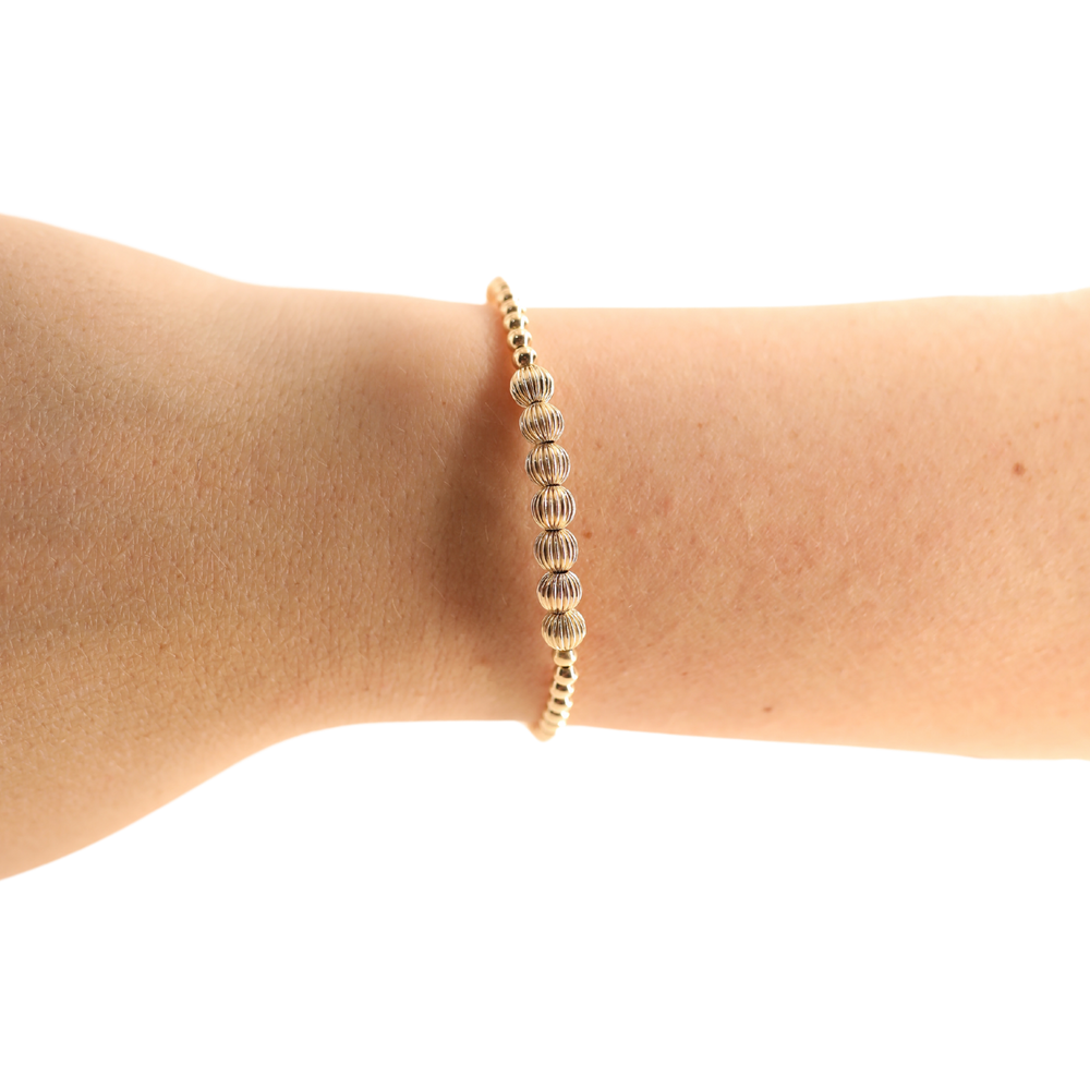 Beaded Blondes Lucky Fluted Bracelet in gold worn on a wrist, featuring textured fluted beads.