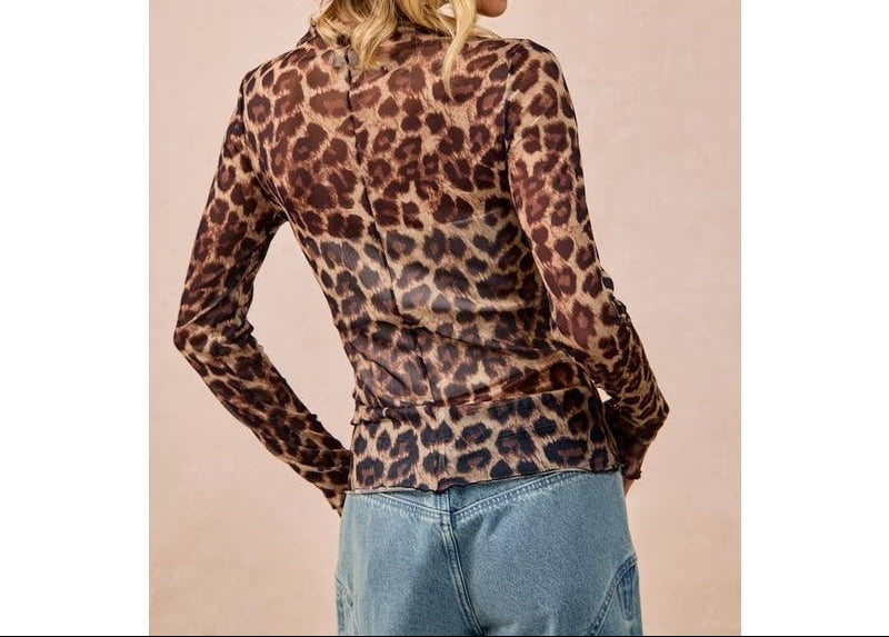 Woman wearing leopard print mesh long-sleeve top with blue jeans and brown hat
