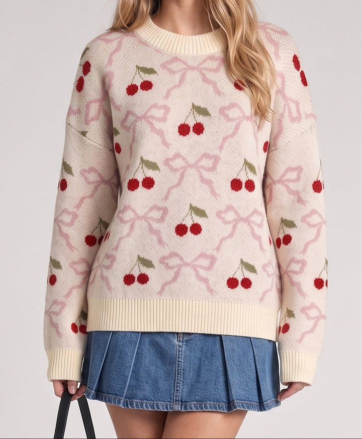 Cream knit sweater with red cherry and pink bow jacquard pattern, worn with denim mini skirt