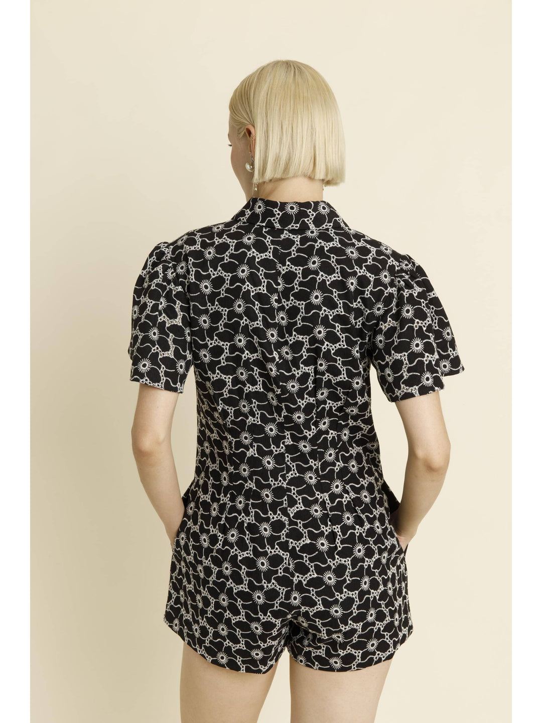 Black patterned short-sleeve romper with collar and shorts, shown from back view