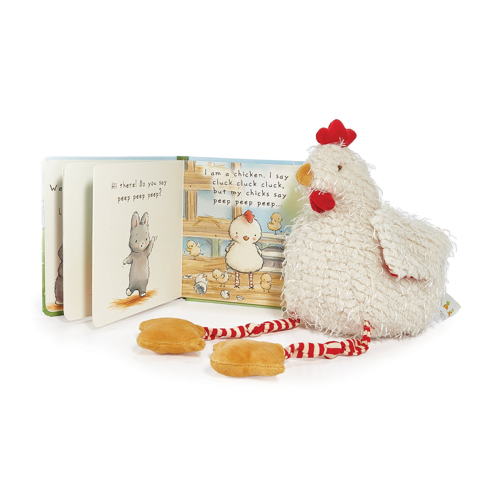 White fluffy chicken plush toy with red-striped legs beside children's book