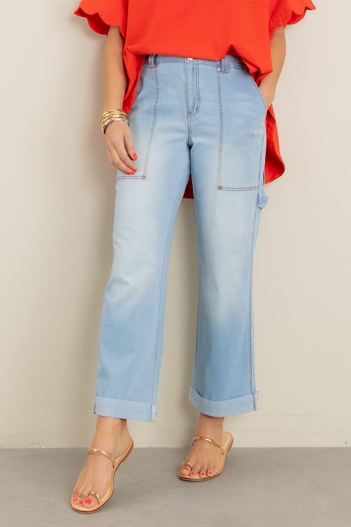 Light blue carpenter jeans with cuffed hems worn with red top and gold sandals