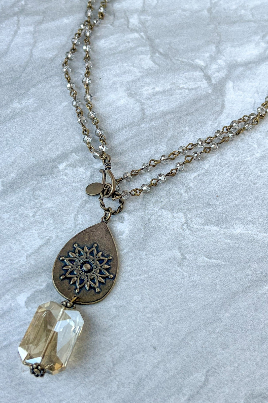 Bronze layered necklace with filigree teardrop pendant and faceted champagne crystal drop