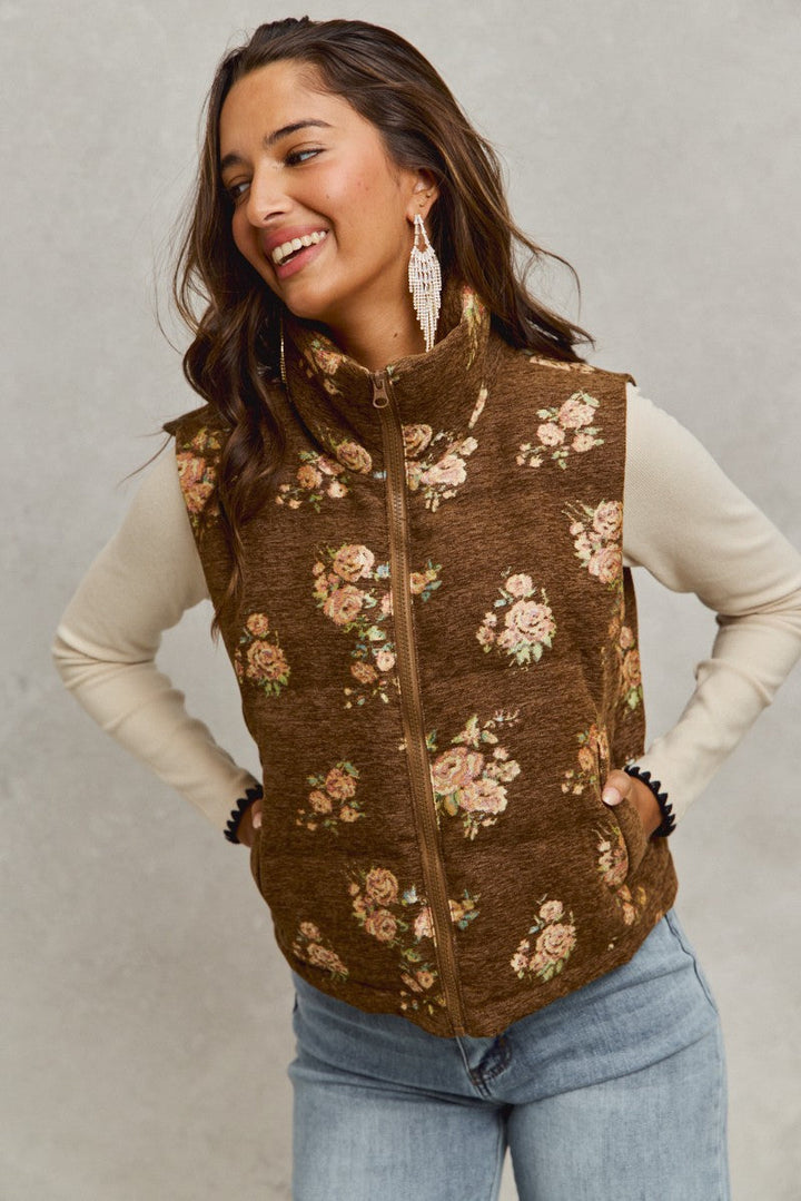 Woman wearing brown floral quilted vest with pink rose pattern over cream long sleeve top