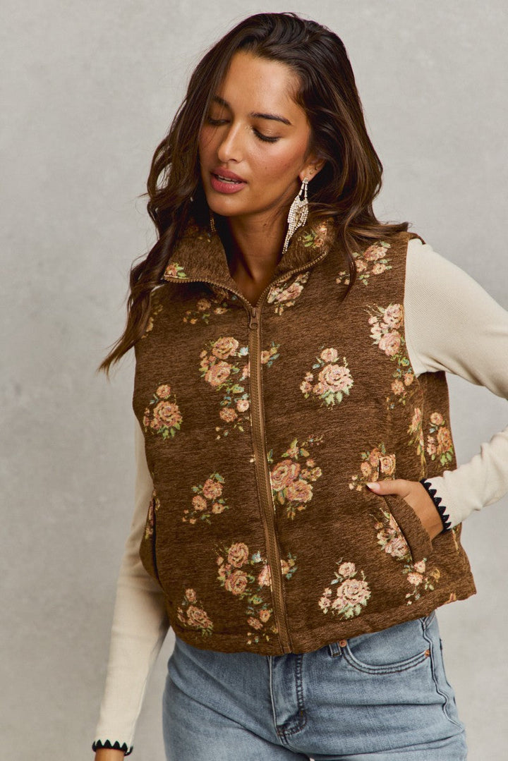 Woman wearing brown quilted vest with pink floral jacquard pattern over cream long-sleeve top