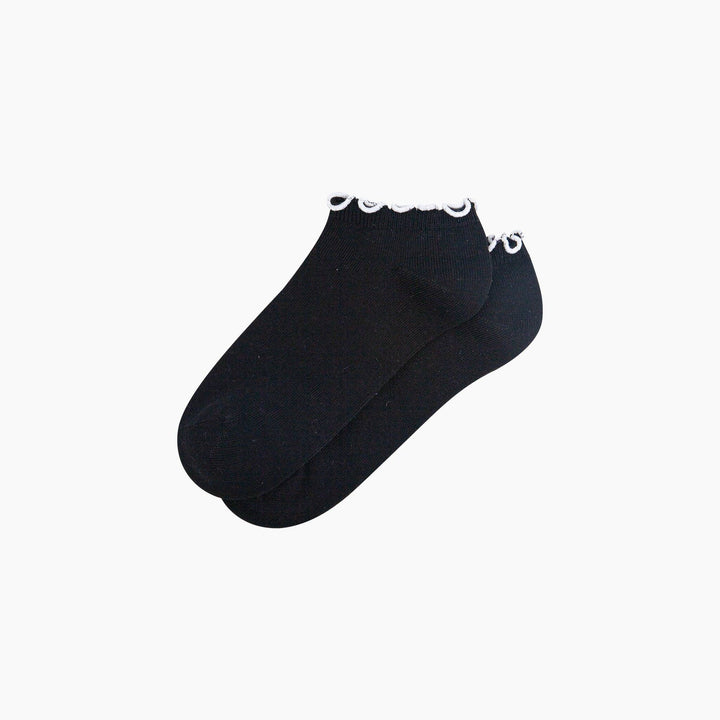 Black ankle trainer socks with white frilly scalloped trim, shown as a pair.