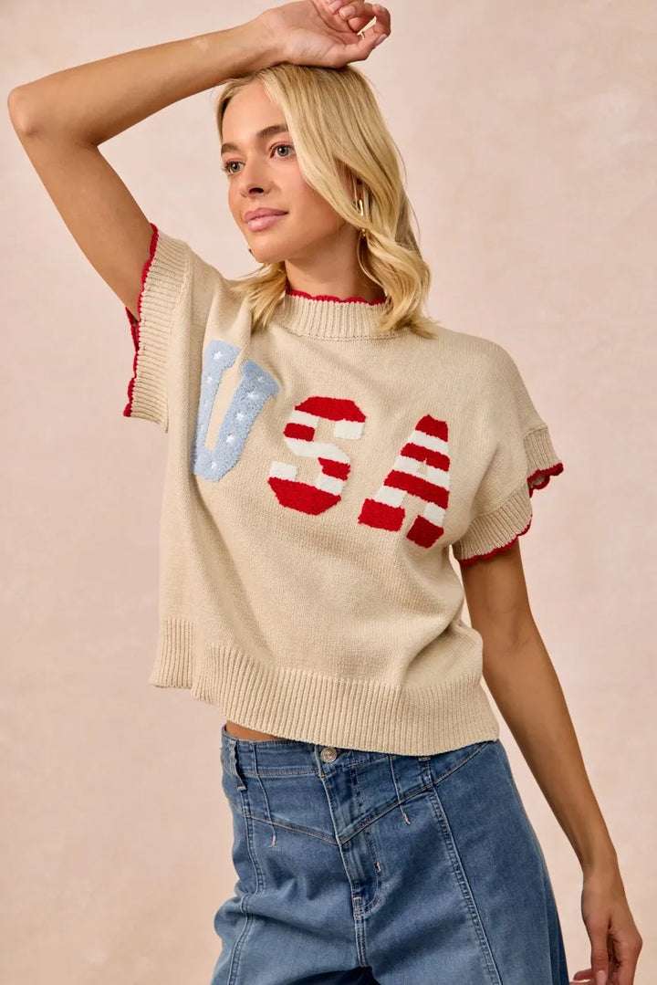 Woman wearing oatmeal knit sweater vest with red and blue USA patchwork design