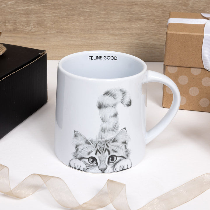White ceramic mug with cute kitten illustration and FELINE GOOD text