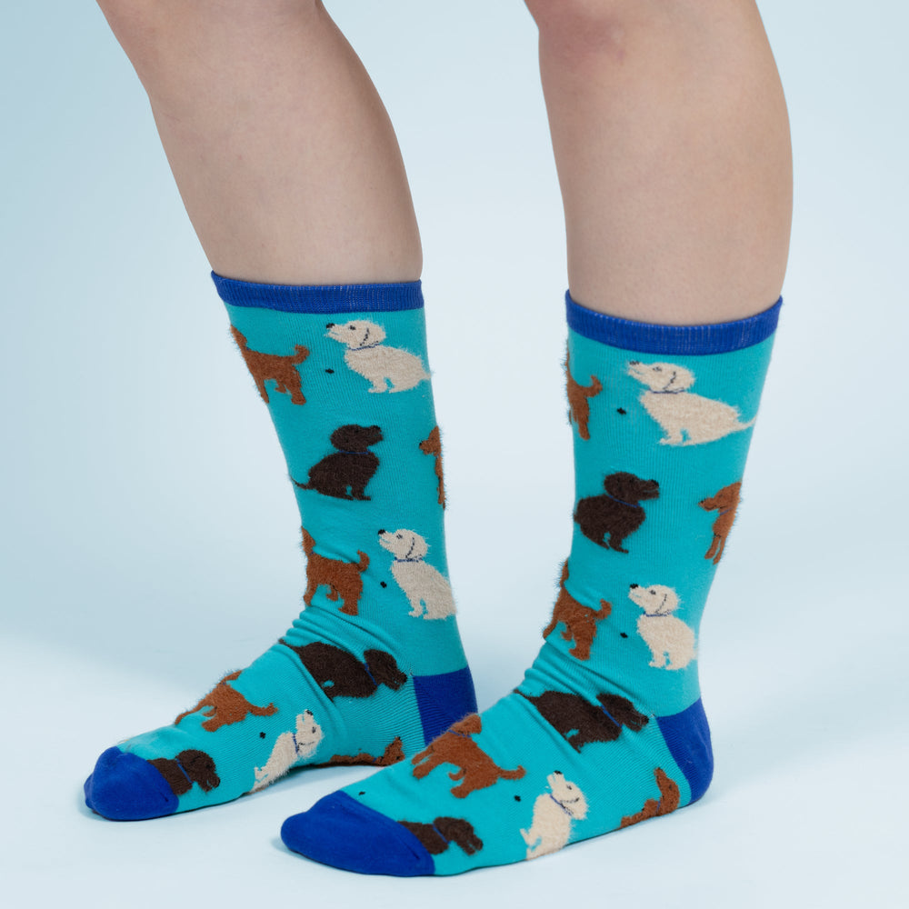 Turquoise crew socks with colorful dog pattern featuring various breeds in different colors