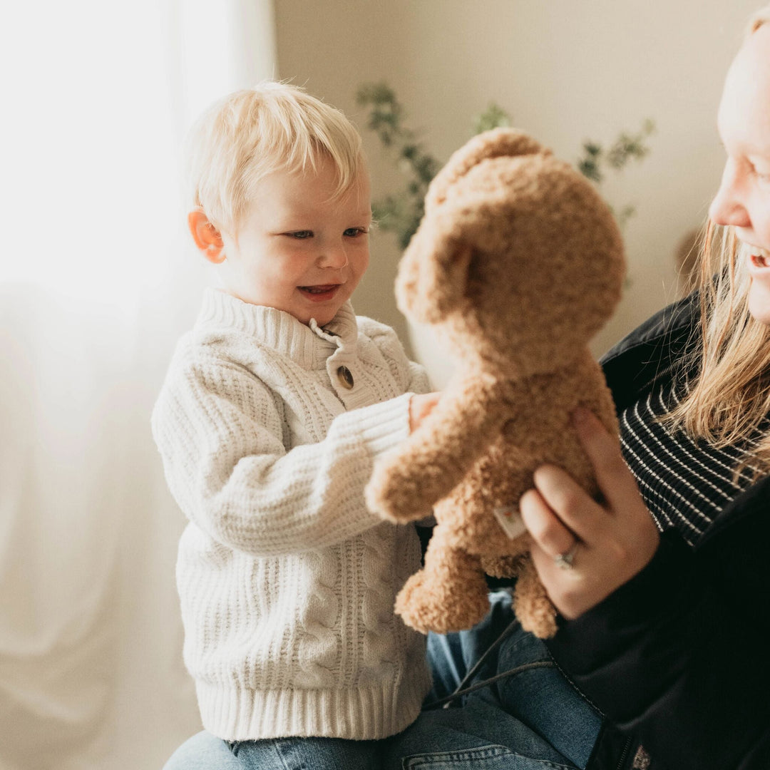 Toddler holds Rufus the Dog stuffed animal plush toy by Bunnies by the Bay
