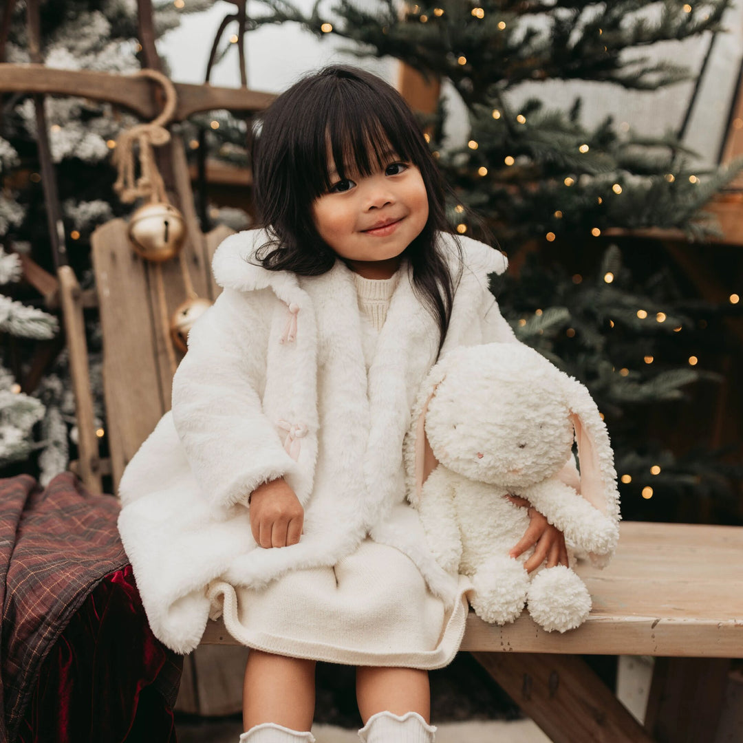 Child holding Snowball the Bunny, a cream white plush stuffed animal by Bunnies By the Bay.