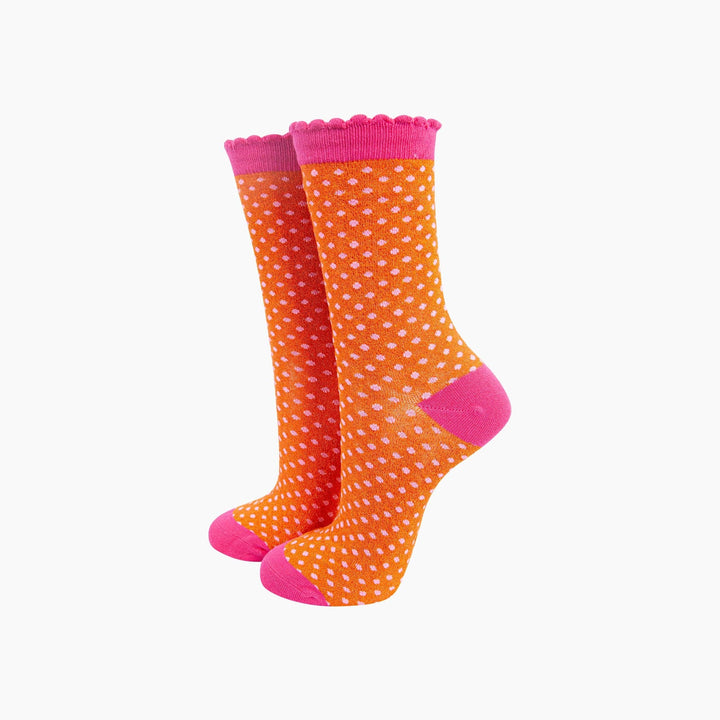 Orange and hot pink polka dot crew socks with scalloped cuff and pink toe and heel