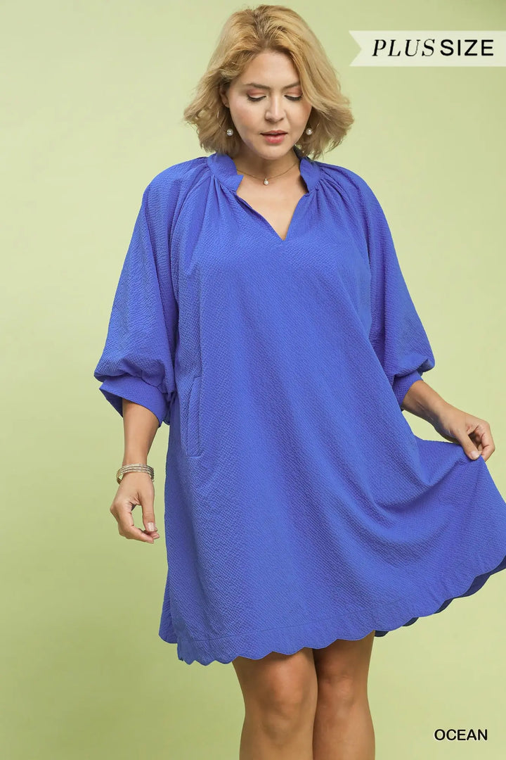 Plus size woman wearing ocean blue textured pocket mini dress with three-quarter sleeves