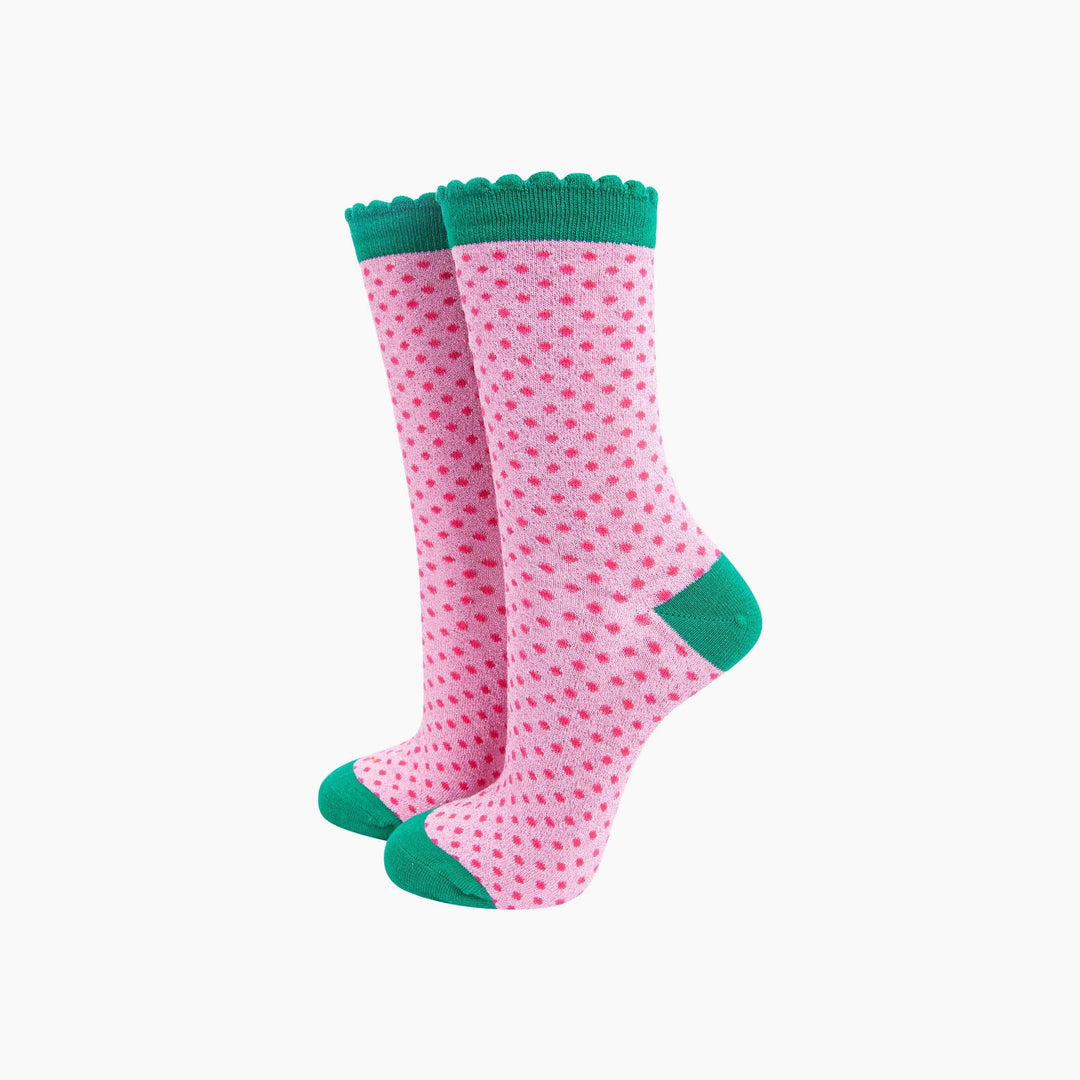 Pink glitter polka dot crew socks with teal scalloped cuff, heel, and toe