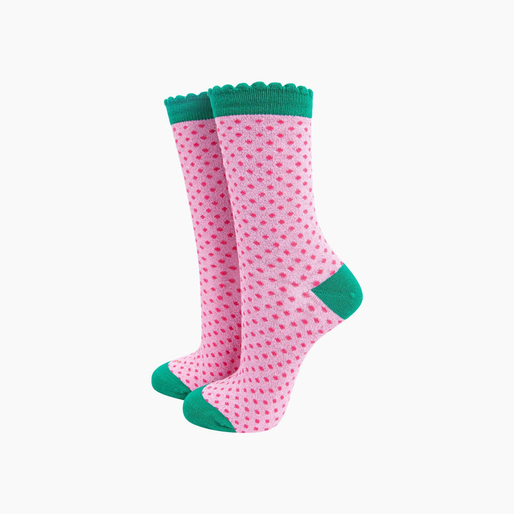 Pink glitter polka dot crew socks with teal scalloped cuff, heel, and toe
