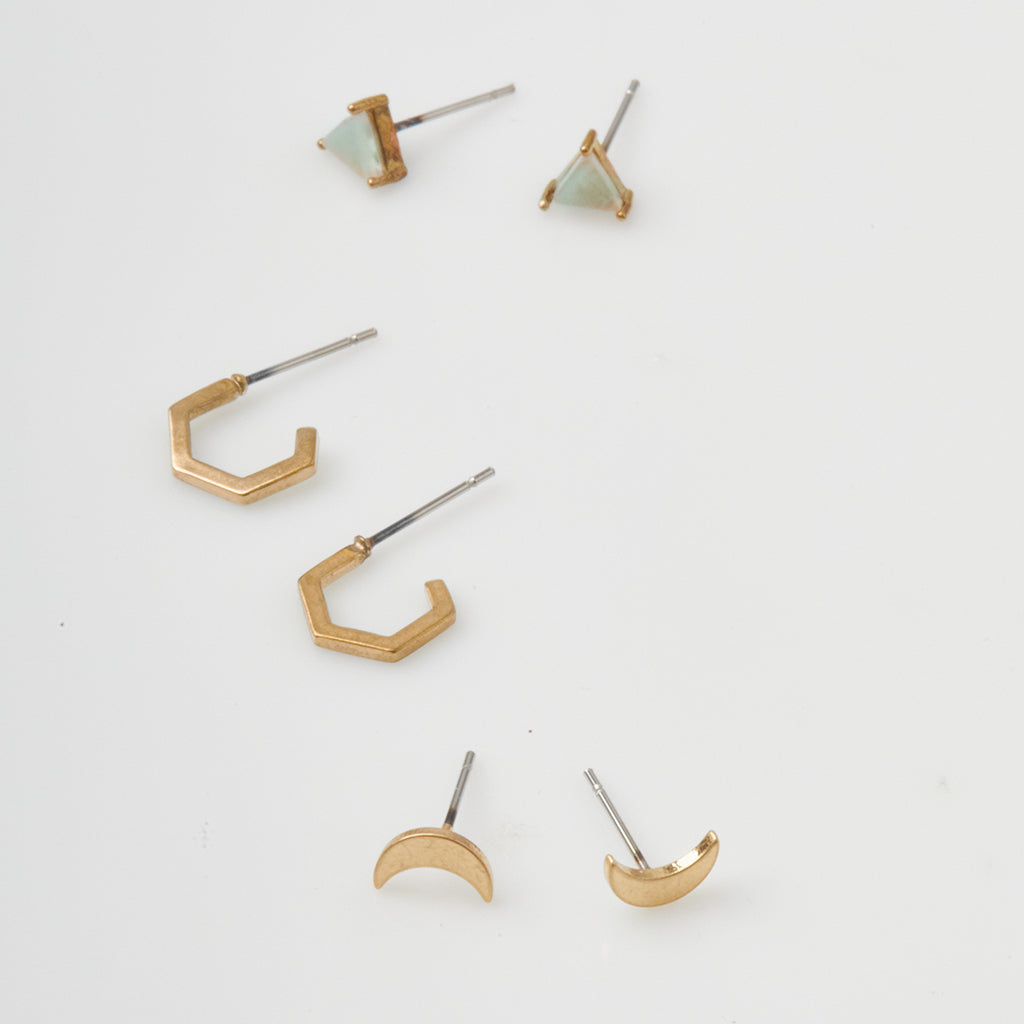 Scout Stud Trio gold earring set featuring triangular studs, hexagonal hoops, and crescent moon shapes