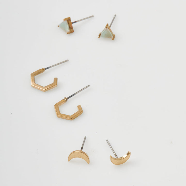 Scout Stud Trio gold earring set featuring triangular studs, hexagonal hoops, and crescent moon shapes
