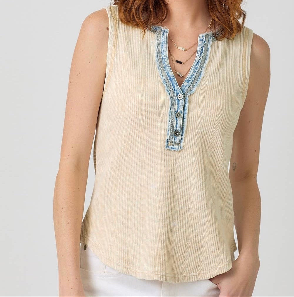 Woman wearing cream ribbed sleeveless top with blue denim collar trim and button details