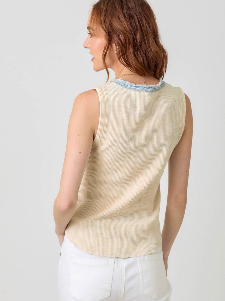 Woman wearing light beige ribbed sleeveless thermal top with blue contrast trim