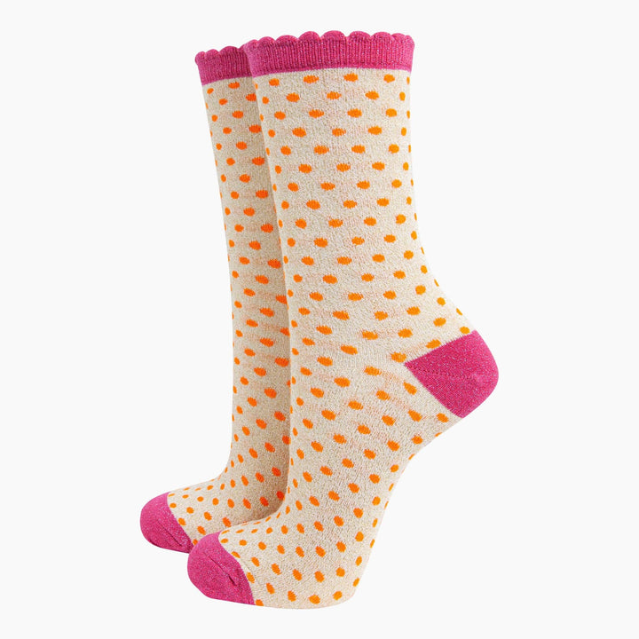 Cream polka dot ankle socks with orange spots and pink scalloped cuff, heel, and toe