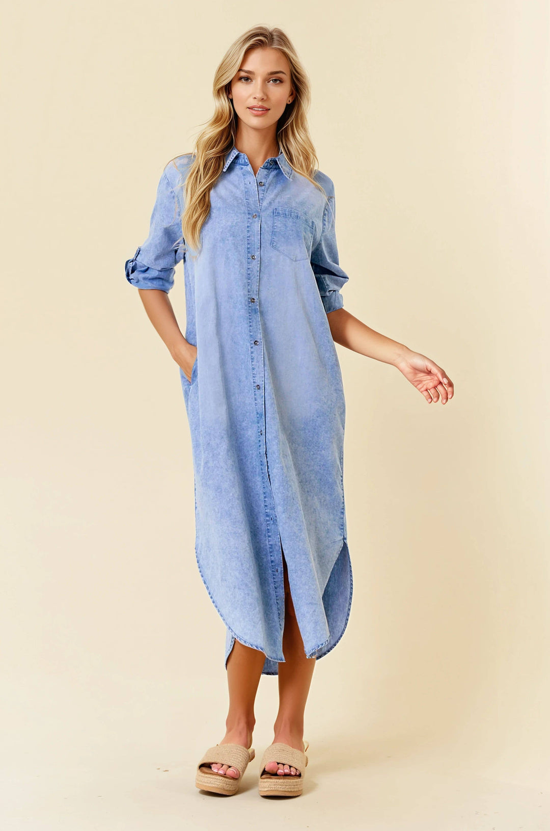 Woman wearing light denim midi shirt dress with roll-tab sleeves and button front