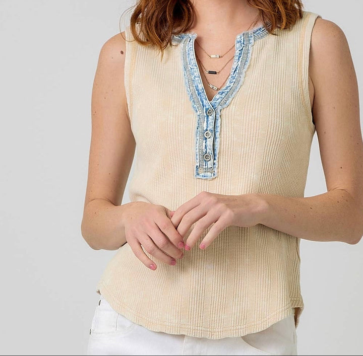 Woman wearing cream ribbed sleeveless top with light blue denim collar trim
