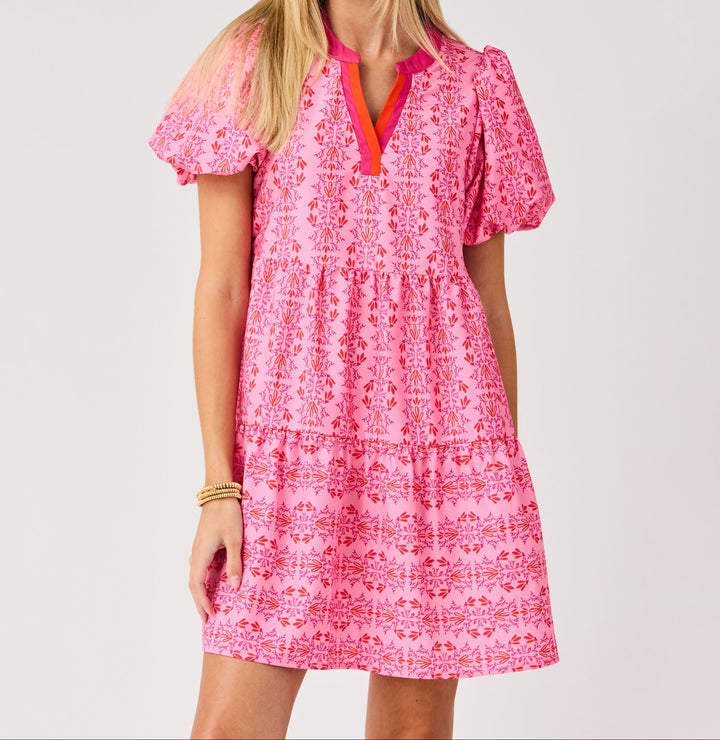 Pink mini dress with red floral vine print, puff sleeves, and tiered ruffle hem