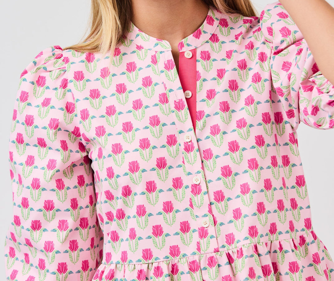 Woman wearing pink floral mini dress with tulip pattern and button front detail