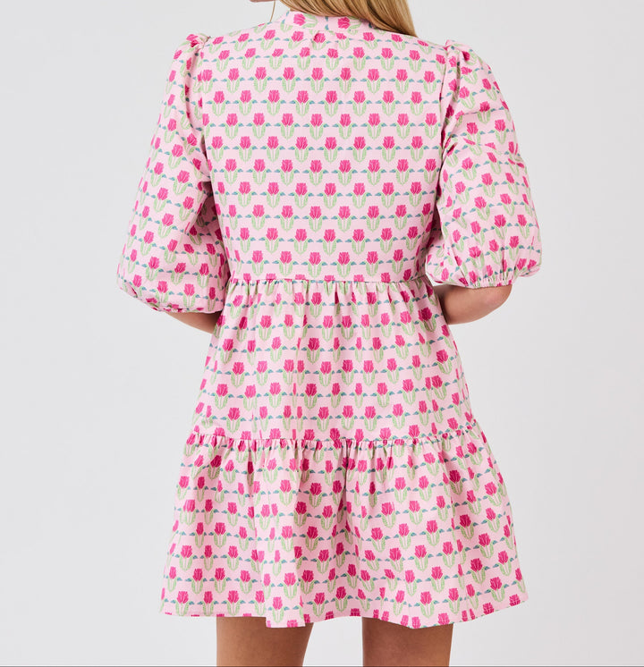 Pink floral mini dress with puffed sleeves and tiered ruffle hem, back view