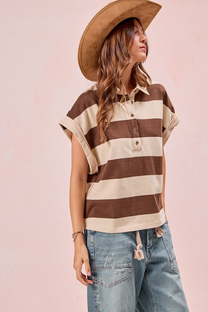 Woman wearing brown and cream striped short-sleeve polo top with jeans and hat