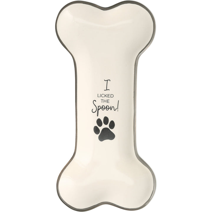 Bone-colored dog bone shaped spoon rest with paw print and 'I licked the spoon' text