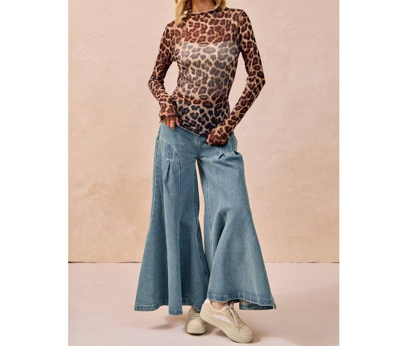 Woman wearing leopard print mesh long sleeve top with wide leg jeans