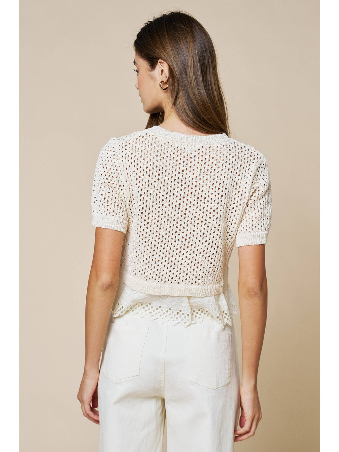 Woman wearing cream open knit short sleeve sweater top with lace hem detail