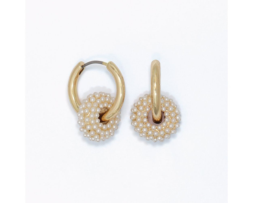 Gold huggie hoop earrings with white seed pearl-covered rondelle pendants