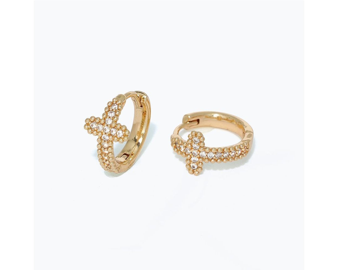 Gold huggie hoop earrings with pavé CZ cross design, shown as a pair
