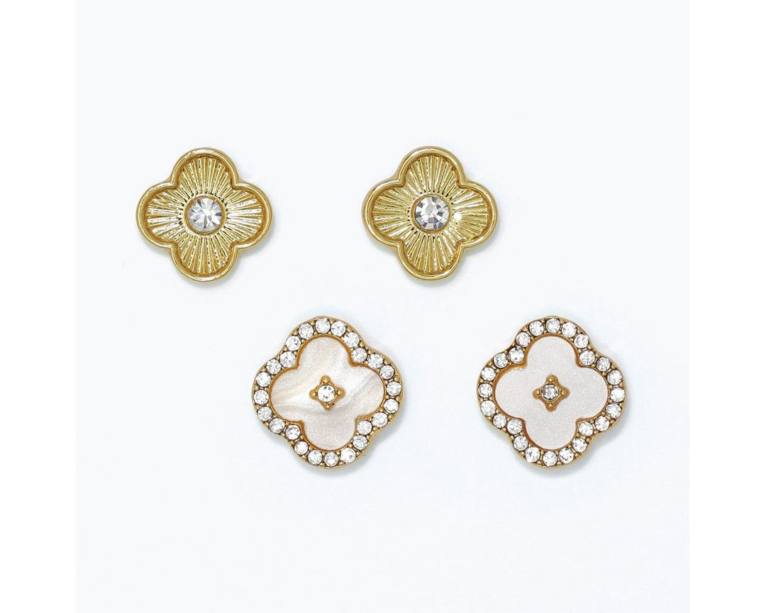Two pairs of gold clover stud earrings with crystal accents and white enamel detailing