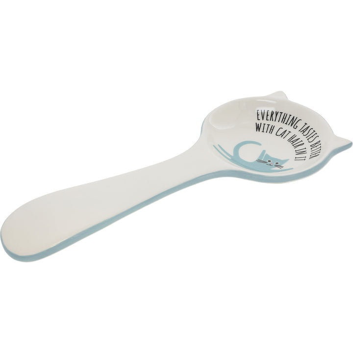 White ceramic spoon rest with cat design and humorous text about cat hair