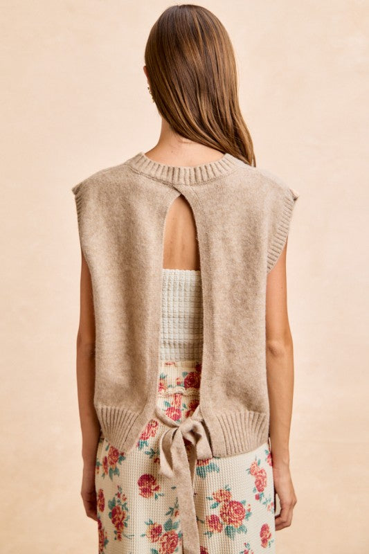 Back view of woman wearing taupe sleeveless knit vest with open back detail and tie
