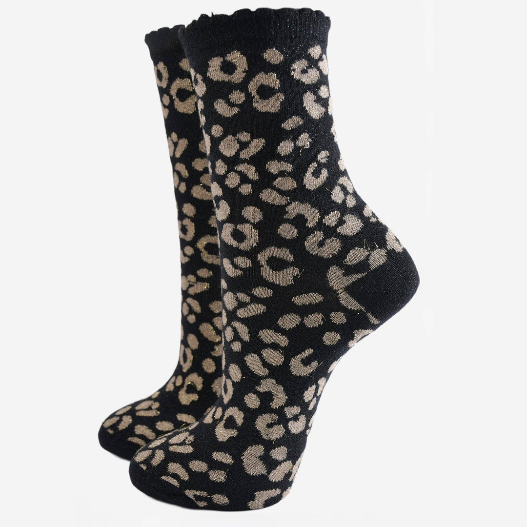 Black ankle socks with gold leopard print pattern and scalloped cuff, shown as a pair