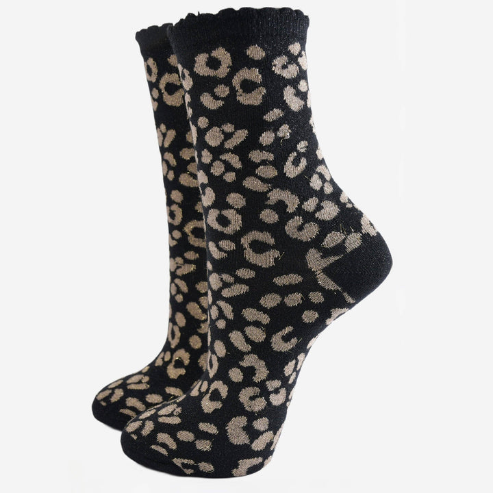 Black ankle socks with gold leopard print pattern and scalloped cuff, shown as a pair
