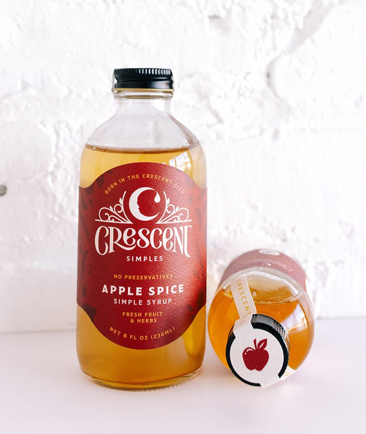 Crescent Simples Apple Spice Simple Syrup bottle with golden amber liquid and red label