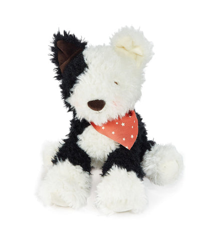 Black and white fluffy farm dog plush toy wearing red polka dot bandana