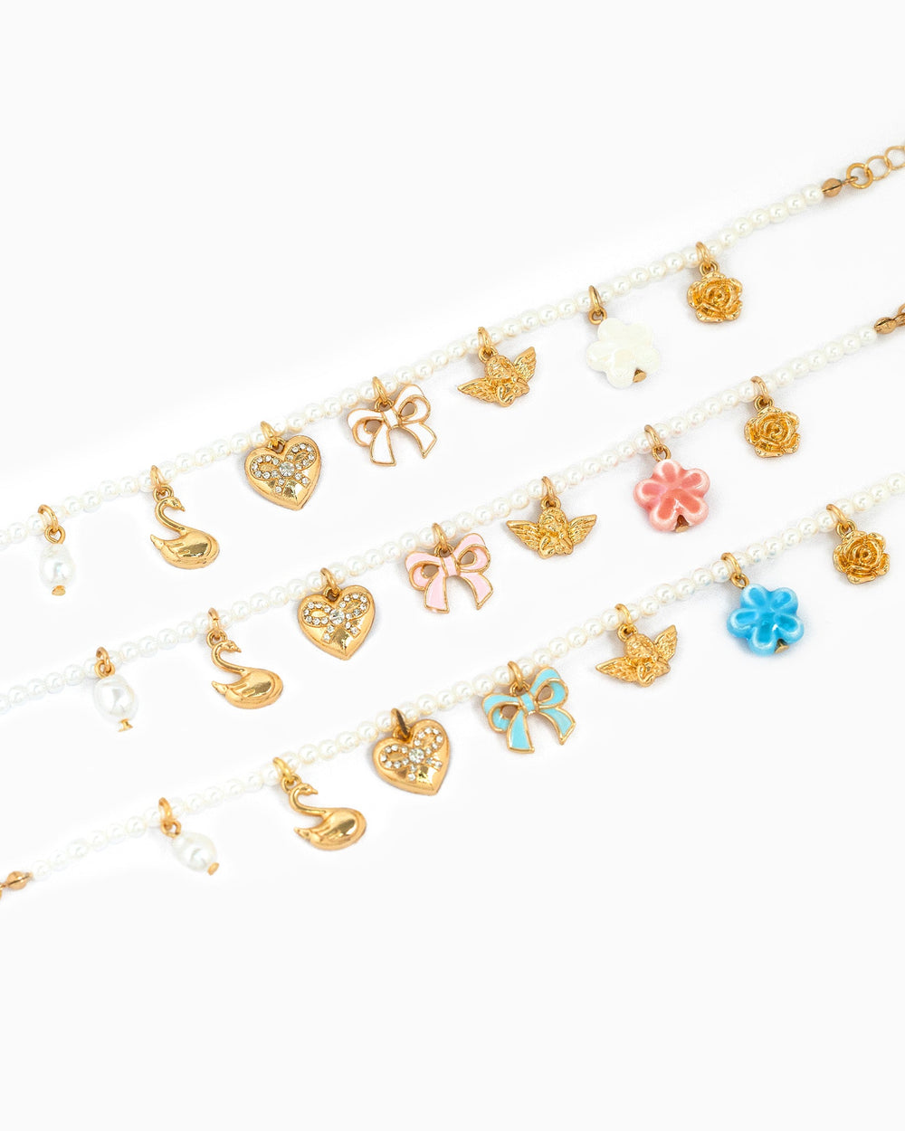 Pearl beaded charm bracelets with gold swan, heart, butterfly, bow, and flower charms in pink tones
