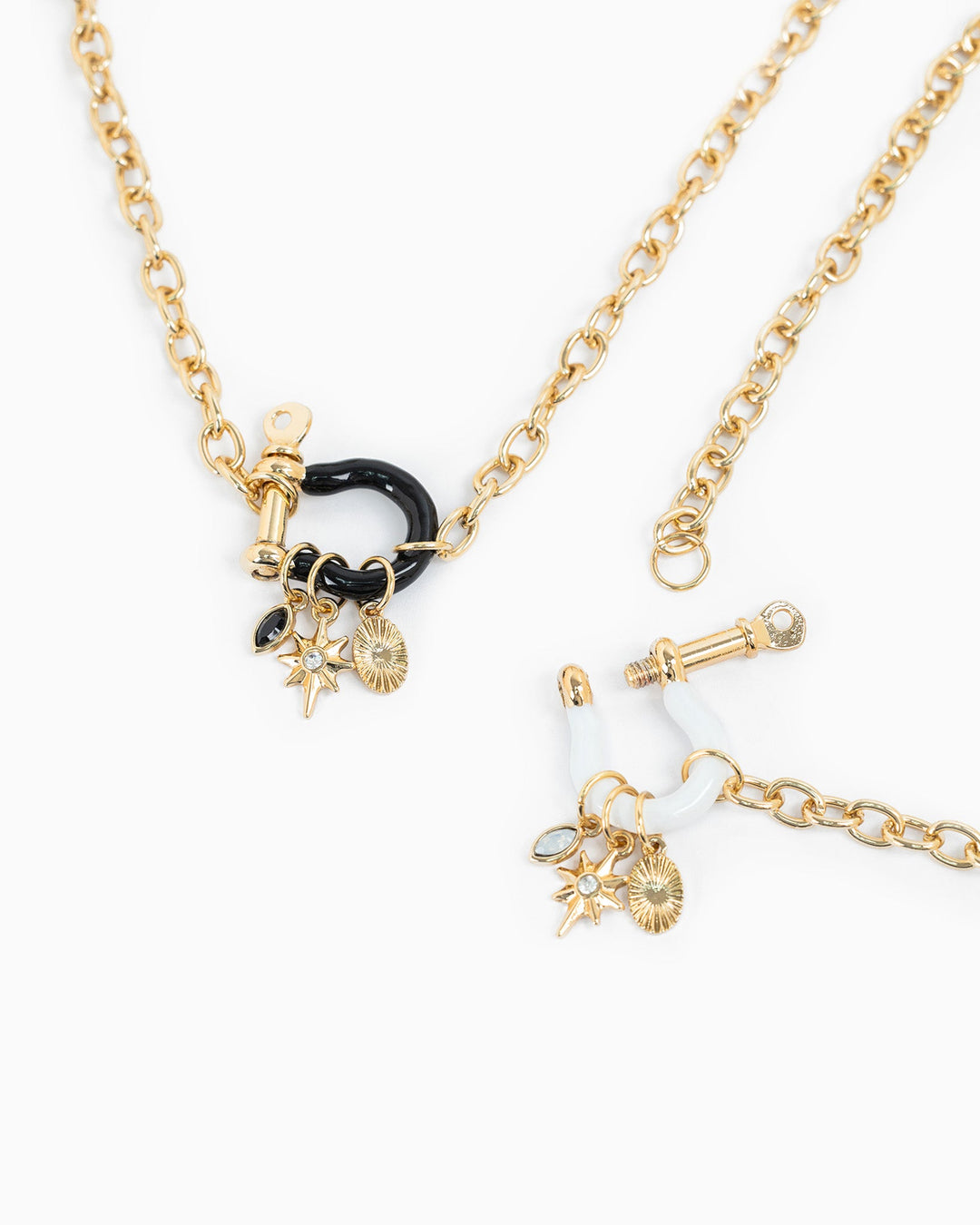Gold chain necklace with black and white enamel horsebit carabiner and three charms including star and coin