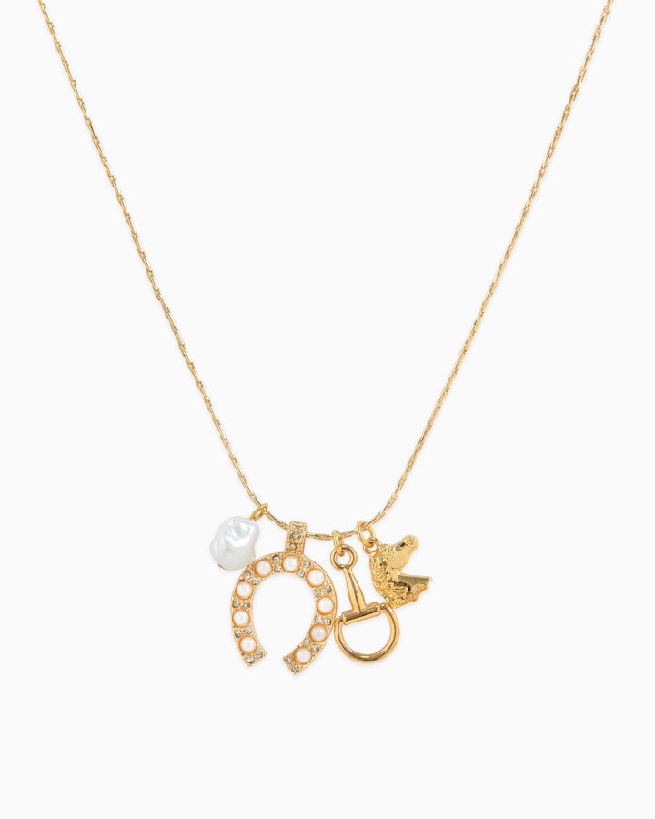 Gold charm necklace featuring horseshoe with pearls, horse bit, bird, and baroque pearl charms