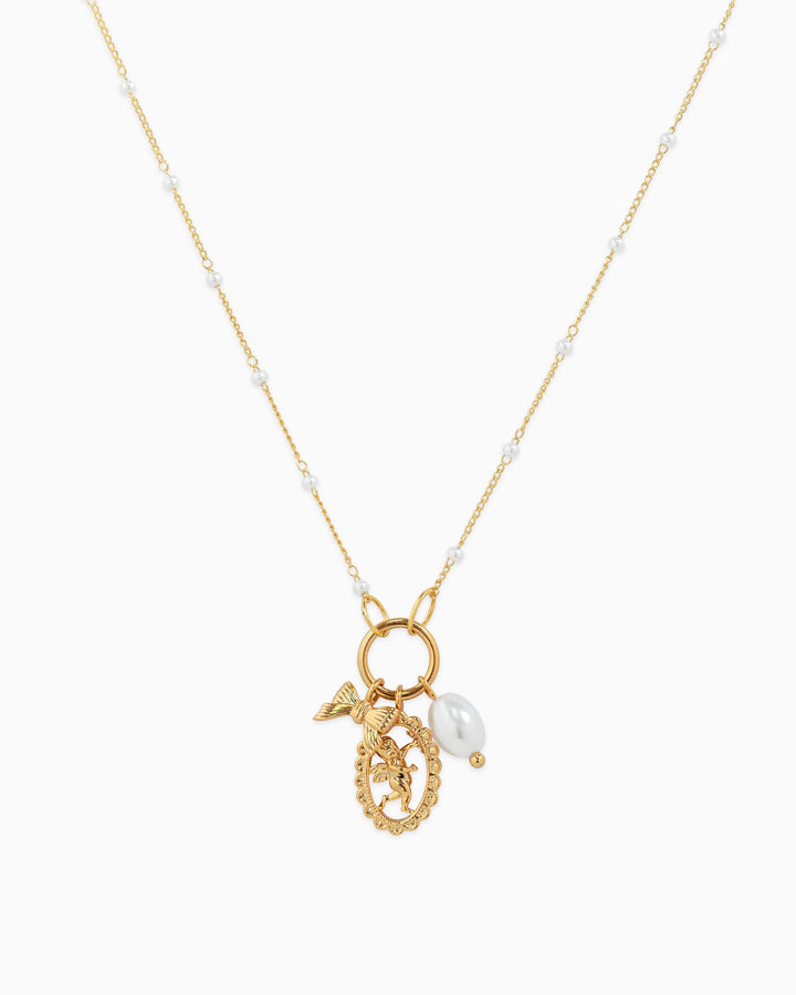 Gold-tone necklace with pearl-studded chain, angel medallion charm, butterfly charm, and baroque pearl drop.