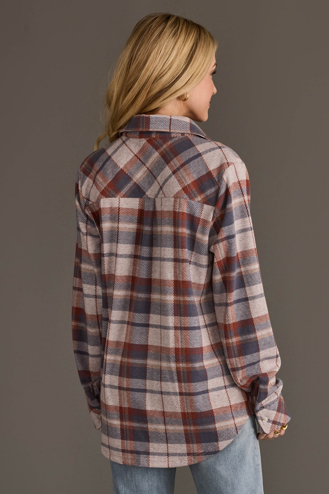 Back view of cream dusty blue and tan plaid flannel button-up shirt on female model